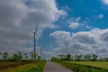 wind turbine on a bright sunny day against the backdrop of a cloudy sky
