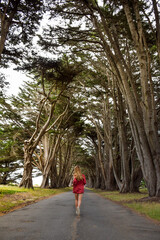 Fototapeta premium Girl running through tree tunnel