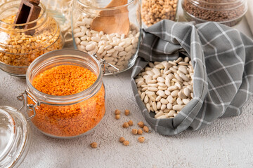 Different legumes in glass jars: chickpeas, pasta, beans, peas, lentils. Zero waste storage, plastic free.