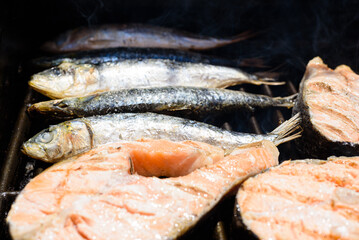 Grilled fresh sardines alongside salmon fillets, great source of protein for keto diets.
