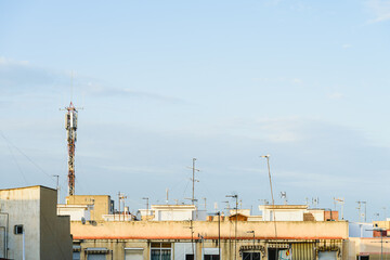 Roofs  of a residential area in the suburbs of a city, with television and telephone antennas.