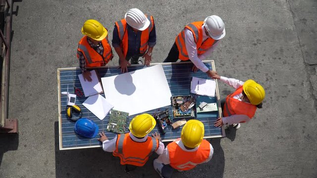 Group of Solar power plant Engineers Team Meeting and handshake together with blueprint on solar cell top table Planning for a New Project of Environmental Power success at construction site outdoors