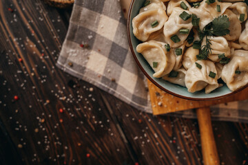 Boiled dumplings in a deep bowl, sprinkled with fresh green onions