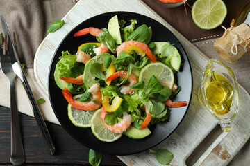 Concept of tasty eating with shrimp salad on wooden table