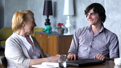 Grandson having conversation with grandmother laughing together