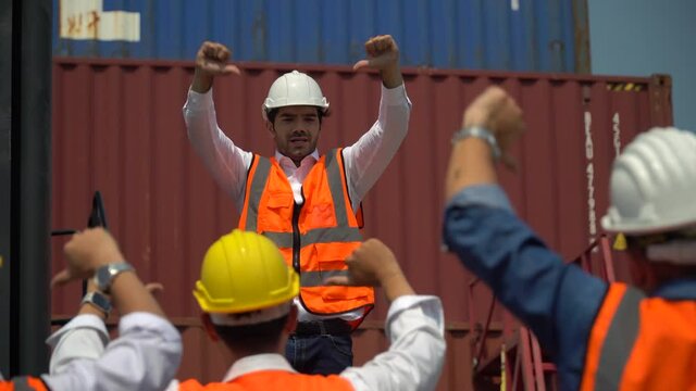 harbor Workers protest in Cargo  freight ship for import export logistic over container box warehouse . Group of protestors shouting and  fists raised up in the air . Strike of labor in industry