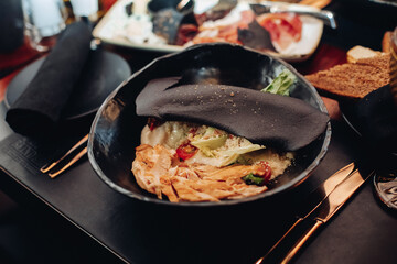 Caesar salad in black bowl.