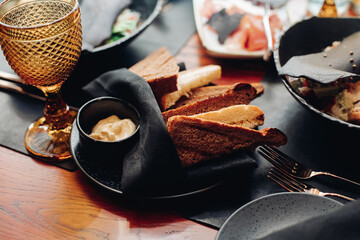 Snack with sauce on black plate with napkin.