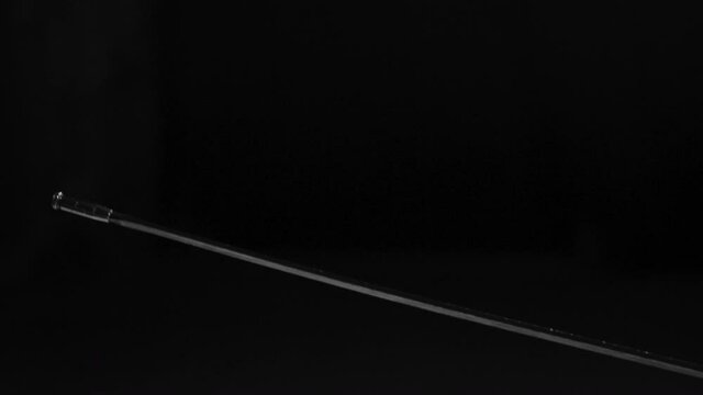 Close up of fencing rapier hitting man in black uniform