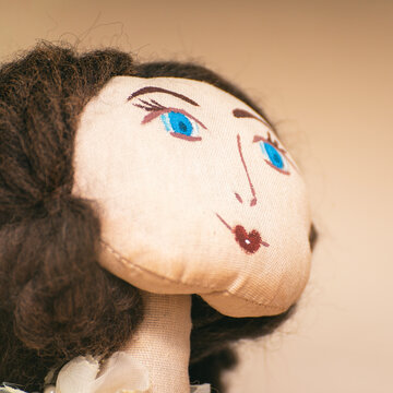 The face of a homemade rag doll with blue eyes. Portrait of a rag doll. Selective Focus