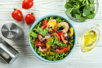 Concept of tasty eating with shrimp salad on white wooden table