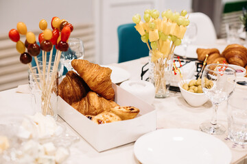 Party catering. Festive dinner table setting with canapes, croissants, different snacks for celebrating event