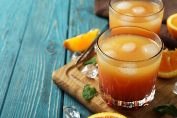 Tequila Sunrise cocktails and ingredients on wooden table