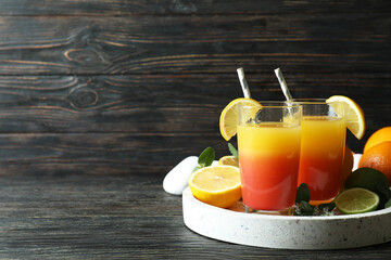Tray with Tequila Sunrise cocktails on wooden table