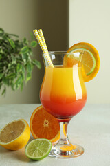 Tequila sunrise cocktail and ingredients on white textured table