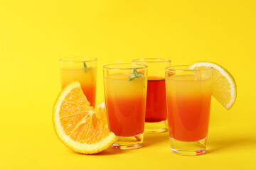 Tequila sunrise cocktails and ingredients on yellow background