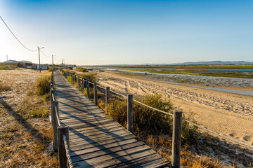 Fototapeta na wymiar Wooden walkways with view on wetlands of Ria Formosa on Faro Beach Peninsula, Algarve, Portugal