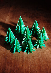 Origami trees isolated on dark background with long shadow.