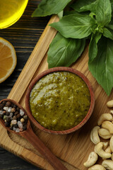 Pesto sauce and ingredients for cooking on wooden background