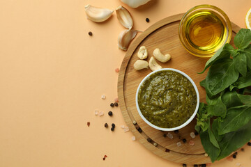 Pesto sauce and ingredients for cooking on beige background