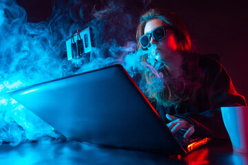 Girl blogger vape. Woman smokes next to a laptop. Blogger girl smokes during video broadcast....