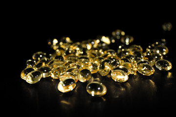 Group of spilled cod liver capsules isolated on black background
