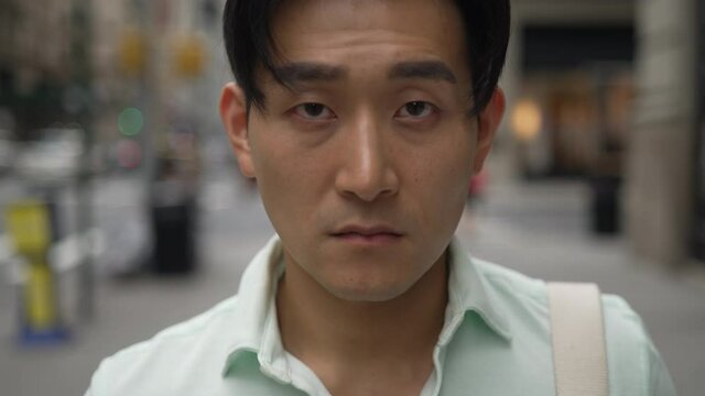 Young Asian Man In City Serious Face Portrait Walking In Closer