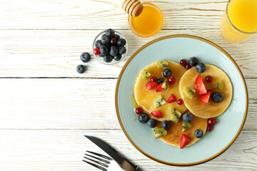 Concept of delicious dessert with pancakes on white wooden table