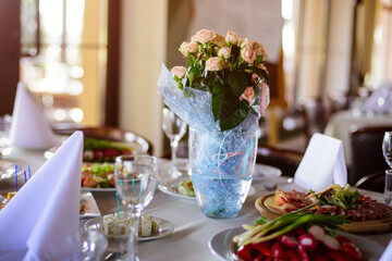 Сatering table with food, flowers and glass stemware at restaurant before party 
