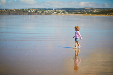 Adorable toddler girl on the sand beach at Atlantic coast