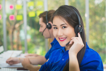 Asian beautiful woman smile in office,call center service,customer operator helpline service center,staff support sale,call center telephone telemarketing sales agent,information service assistant - obrazy, fototapety, plakaty