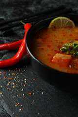 Concept of tasty eating with Tom yum soup on black smokey background