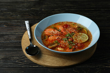 Tasty Tom yum soup on wooden background