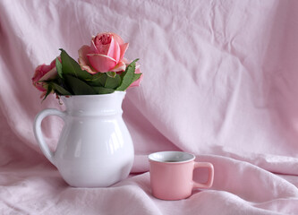 Spring, summer still life scene. Vintage wedding feminine styled photo, floral composition. Bouquet of pink roses in a white vase and cup of coffee.