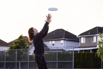 White Caucasian Adult Woman Playing Ultimate Frisbee in the Green Field at neighborhood city park....