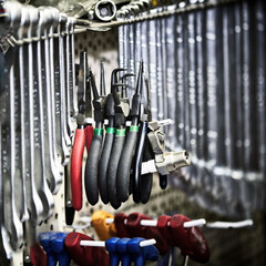 Fototapeta premium Close-up of work tools and wrenches hanging on the wall in the workshop