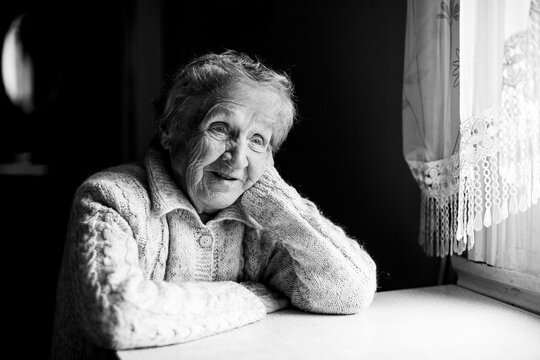 Portrait Of An Old Woman. Black And White Contrast Photo.