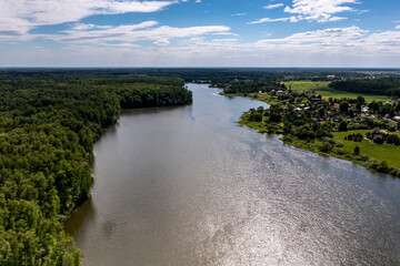 panoramic view from the drone to the village of a large lake and forest and fields and roads 