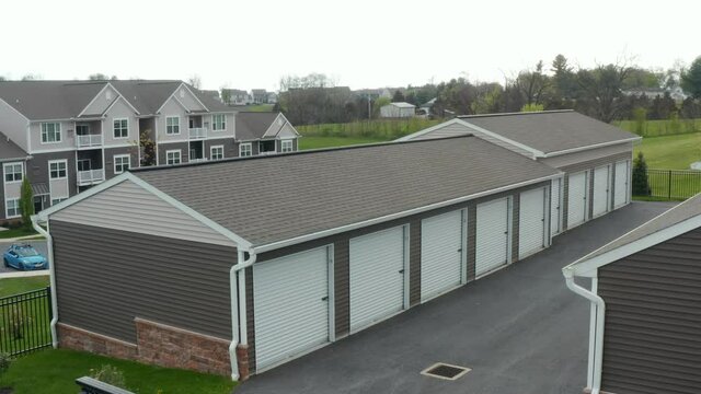 Self storage rental unit building for keeping personal belongings. Aerial view with residential apartment buildings in background.