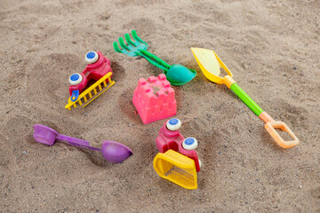 selective focus colorful children's toys on the sand Toy car and toy shovel concept in the technology age Children only play mobile phone games. They don't play with toys like before.