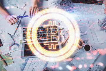 Double exposure of man and woman working together and crypto finance theme hologram. Blockchain...