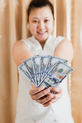 woman smile holding a mock-up hundred-dollar money banknote for shopping. selective focus.