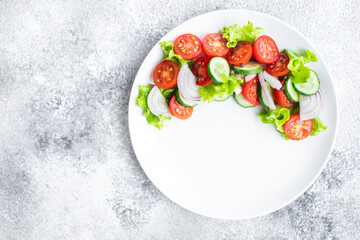 fresh salad vegetables tomato, cucumber, onion, lettuce organic dish on the table healthy food meal snack copy space food background rustic. top view keto or paleo diet veggie vegan or vegetarian