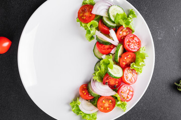 fresh salad vegetables tomato, cucumber, onion, lettuce organic dish on the table healthy food meal snack copy space food background rustic. top view keto or paleo diet veggie vegan or vegetarian