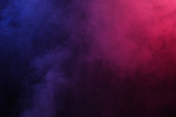 Artificial magic smoke in red-blue light on black background