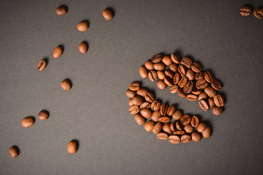 Horizontal background image of Coffee bean shape isolated on dark background. Coffee seed silhouette  with scattered roasted high quality coffee beans on background. Aroma drink
