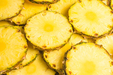 Pineapple juicy yellow slices background. Top view.