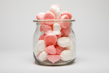 Colorful candies in jar on table background