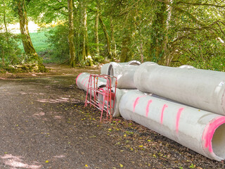 Sewer pipes on a forest road for the construction of a water drainage system.