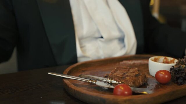 A fat man sits at a table in restaurant.